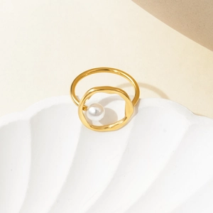 Detail view of gold titanium steel ring with irregular band and elegant white pearl