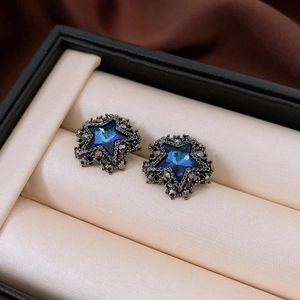 Macro di orecchini vintage a stella con cristalli blu intenso e strass scuri raffinati