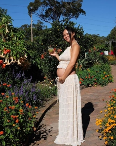 Detail view of two-piece maternity set with halter ruffle top and pleated long skirt