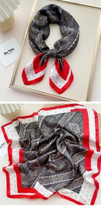 Detail of elegant silk square scarf with paisley pattern and red contrast border