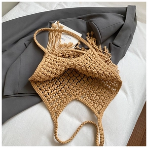 Detailed macro view of beige macrame woven pattern and fringe on handmade shoulder bag