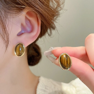 Close-up of vintage tiger eye stone geometric earrings with elegant gold metallic edging