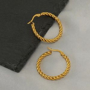 Polished gold twisted rope hoop earrings displayed on a premium textured grey stone surface