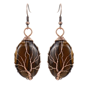 Macro shot of handmade wire-wrapped tree of life earrings with tiger eye stones