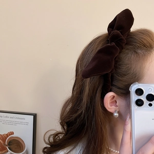 Close-up of deep brown velvet knot headband with a stylish knotted bow design