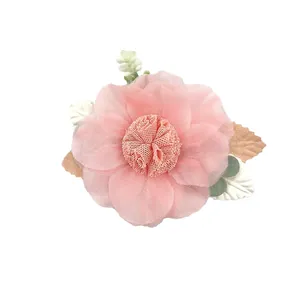 Detail of pink fabric flower hair clip with translucent tulle petals and floral accents