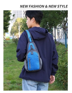 Blue waterproof sling bag for men worn by model in an outdoor city setting