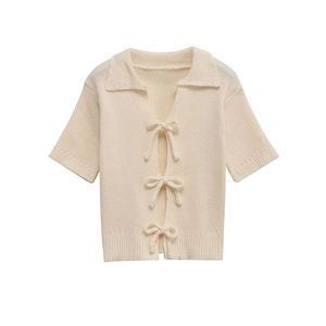 Detail of the bow-tie ribbon closures and ribbed texture on this cream knit cardigan