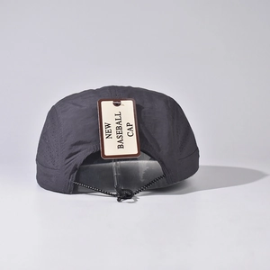 Vue détaillée d'une casquette de plein air gris foncé avec panneaux en mesh et cordon