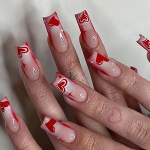 Macro detail of red gradient French square press-on nails with 3D heart and star designs