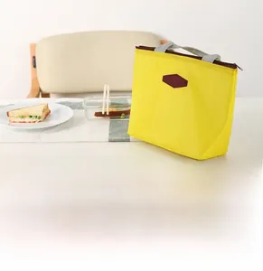 Detail of yellow thermal lunch bag with zipper closure and durable top handle
