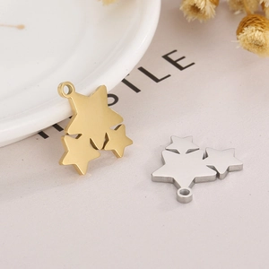 Minimalist stainless steel star pendants in gold and silver finish shown on a ceramic dish