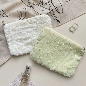 Detail of 3D chiffon floral embroidery on small zipper makeup pouch with pearl accessories