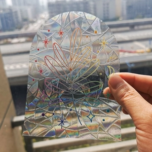 Close-up of arched rainbow suncatcher window film with laser leaf and moon pattern