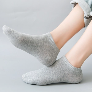 Gray low cut invisible cotton boat socks with ribbed cuffs shown on model's feet