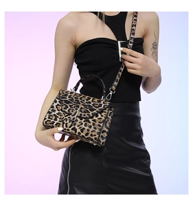 Detail of leopard print handbag with metallic handle and adjustable shoulder strap