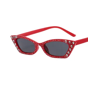 Red cat eye sunglasses with rhinestones and dark lenses seen from a 45-degree angle