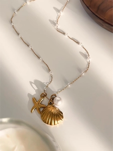 Detail of gold starfish and shell pendant necklace with elegant white pearls