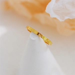 Detailed close-up of 18K gold-plated star pattern engraving on a minimalist ring