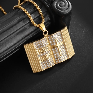 Macro shot of gold-plated stainless steel holy bible pendant with cross and clear crystals