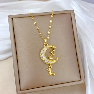 Detail of gold titanium steel necklace with sparkling moon pendant and star charms