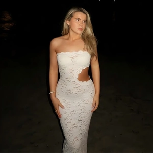 Dettaglio dell'abito in pizzo bianco con spacco in vita e fondo a sirena elegante