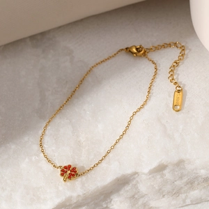 Elegantes goldenes Edelstahlarmband mit einem roten Strass-Kleeblatt-Anhänger