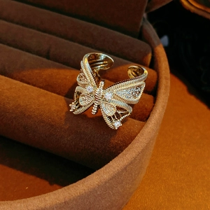 Macro shot of gold butterfly ring with white zircon inlays and vintage hollow details