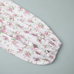 Detailed view of floral print dress featuring elastic smocked cuffs and lantern sleeves