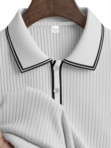 Detail of white striped polo collar and knit texture on a wooden hanger background