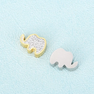 Golden and silver elephant pendants with sparkling rhinestones on light blue texture