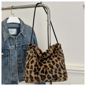 Detail of soft leopard print faux fur tote bag hanging next to a denim jacket