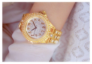 Vue détaillée d'une montre de luxe dorée sertie de cristaux et chiffres arabes