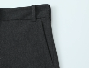 Dettaglio della vita di pantaloni grigio scuro con passanti e tasche laterali