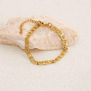Macro view of gold-plated stainless steel chain with lobster clasp on natural stone