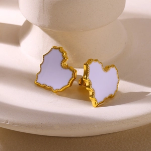 Detailed view of irregular gold-plated heart earrings with white enamel on a stone base
