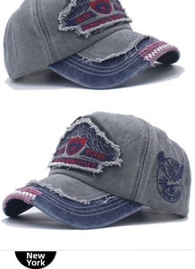 Close-up of vintage distressed denim cap with grey cotton and navy blue embroidery