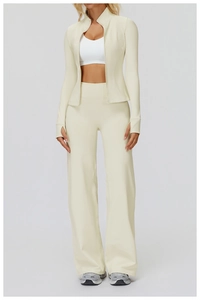 Détail de la veste de sport crème à fermeture éclair et pantalon de yoga large assorti