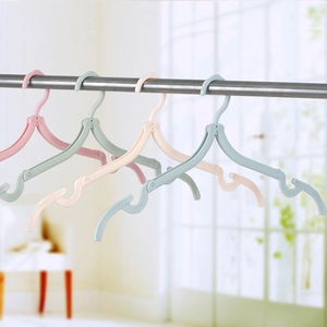 Foldable portable travel hangers in four pastel colors hanging on a metal rod