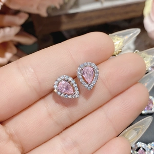 Macro shot of pink pear-cut gemstones in a halo setting with silver-tone plating