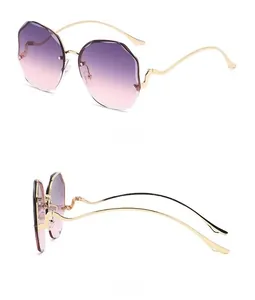 Detail of frameless gradient purple lenses and wavy gold metal temples on sunglasses