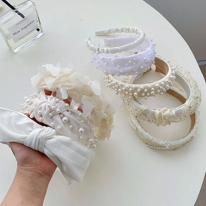 Detail of white pearl headbands and chiffon bow hair accessories for women