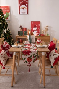 Runner da tavola natalizio con motivi a stella di Natale e nappe su tavola festiva
