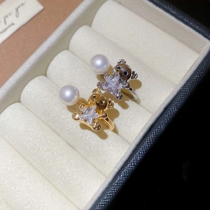 Macro view of gold and silver bear rings with star crystals and pearls in a jewelry box