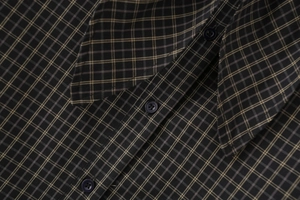 Detail of classic plaid flannel shirt showing button-down collar and woven texture