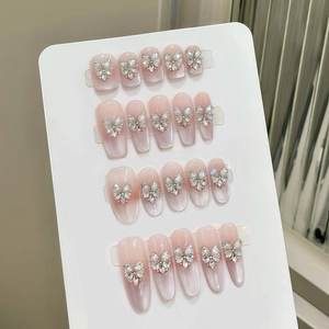 Detailed view of pink cat-eye handmade press-on nails with silver 3D diamond butterflies