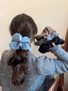 Detailed view of handmade polka dot hair scrunchies in various colors on a model