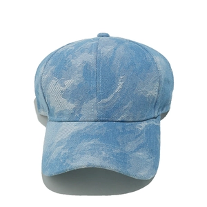 Detailed view of light blue denim baseball cap featuring unique tie-dye cloud patterns