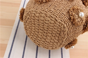 Detail of hand-woven paper rope bucket bag with raffia flowers and pearl accents