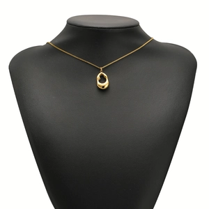 Polished gold stainless steel heart pendant necklace displayed on a black bust